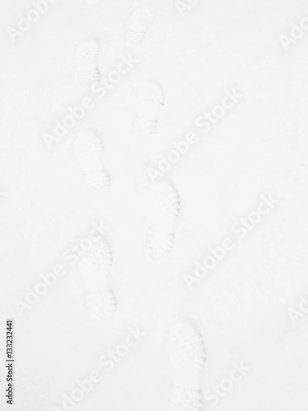 Fototapeta Closeup of footsteps in snow going forward