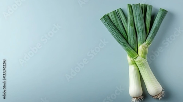 Obraz Fresh leeks on a blue background.