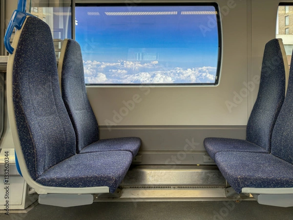 Fototapeta Empty Train Seats Facing Window with Scenic Cloud View