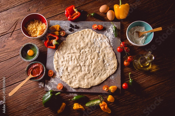 Fototapeta Preparing pizza with dough and tomato sauce