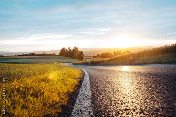 Fototapeta Droga miejska o zachodzie słońca w polu, słońce, wieczór