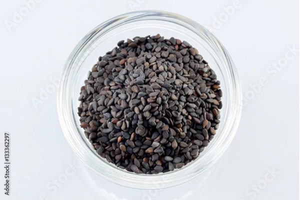 Fototapeta Pile of black sesame seeds on bow  isolated on white background