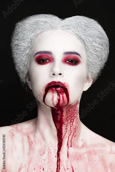 Fototapeta Mysterious beauty portrait of snow queen covered with blood. Bright luxury makeup. Gore dripping from the mouth.