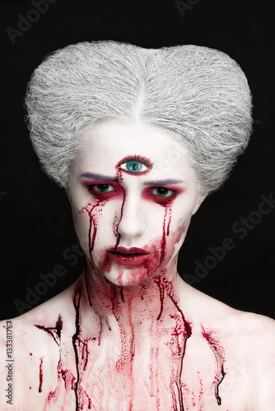 Fototapeta Mysterious beauty portrait of snow queen covered with blood. Bright luxury makeup. Gore dripping from the mouth.