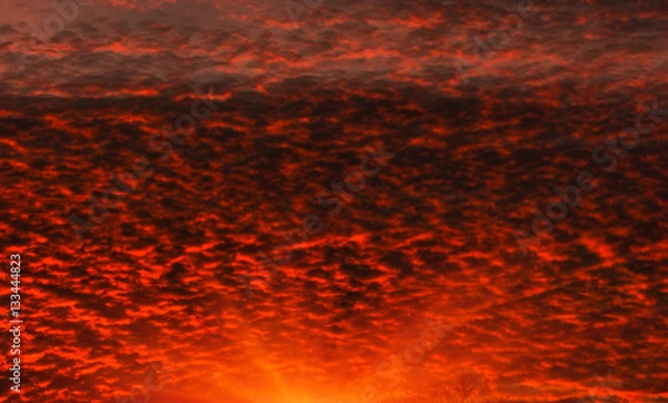 Fototapeta Fiery orange sunset  colorful and speckled  clouds. Beautiful sk