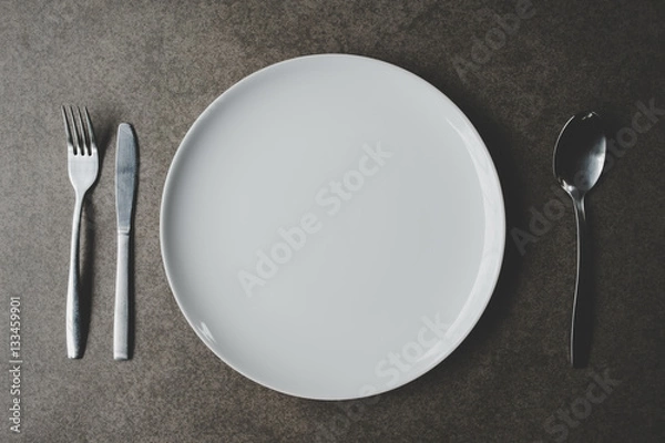 Fototapeta Spoon and Fork Tied on a White Napkin on Wooden Table