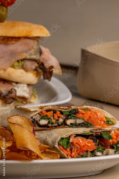 Obraz Chicken and salmon sandwich wraps without tac on a plate with sweet potatoes and guacamole sauce