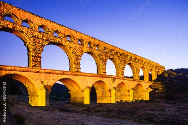 Obraz Pont du Gard, ancient Roman aqueduct bridge, colorful projection mapping video show, under Provence starry night sky, Gorges du Gardon, natural landscape designated Biosphere Reserve by UNESCO, France