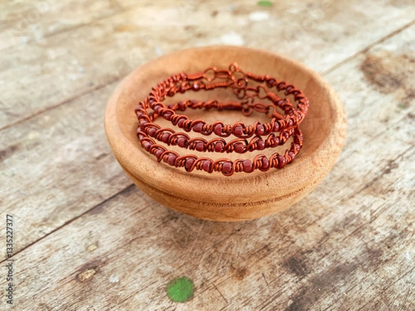 Obraz handmade wire copper bracelet on wooden table
