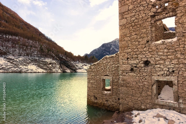 Obraz Alpine lake with ruins of old houses partially submerged by water