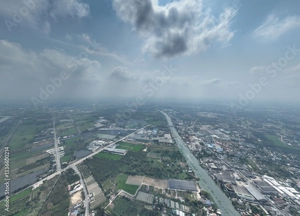 Fototapeta The River's Embrace: An Aerial Glimpse of little town Urban Heart. This drone photograph captures a wide aerial view of Nakhon Pathom, Thailand, with a focus on the river that flows through town