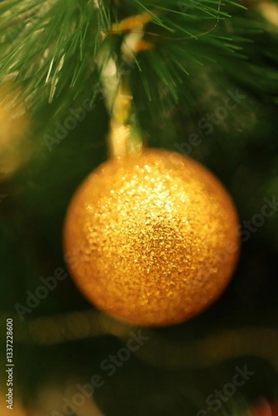 Obraz Golden New Year's ball on the Christmas tree. Beautiful shiny decoration.