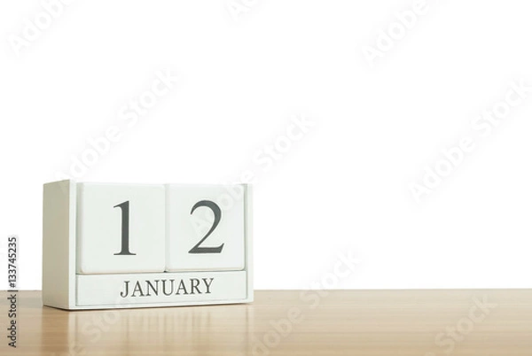 Fototapeta Closeup surface white wooden calendar with black 12 january word on blurred brown wood desk isolated on white background with copy space , selective focus at the calendar
