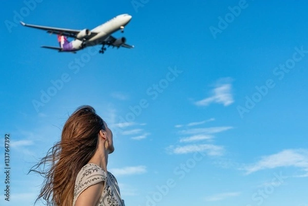Fototapeta 青空の下で飛行機を眺める女性