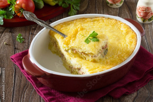 Fototapeta Casserole with potatoes, meat and cheese on a wooden table. Spac