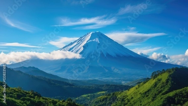 Fototapeta Stunning perspective of the snowy peak set against a clear blue sky with a few clouds observed from the outskirts.