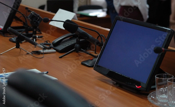 Fototapeta Press media conference studio with monitors, microphones on wooden table