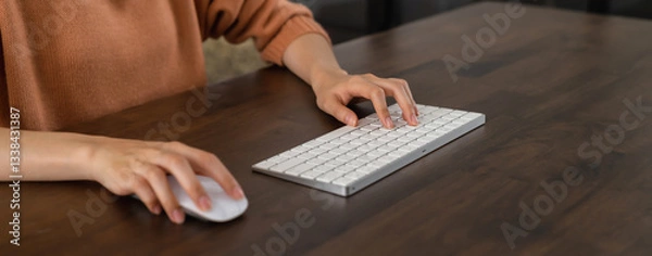 Fototapeta Close up of hand press the button computer mouse and type text on keyboard on table.