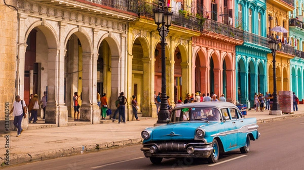 Obraz Niebieska taksówka oldtimer przejeżdża przez Habana Vieja przed kolorową fasadą