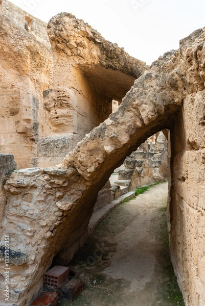 Fototapeta Stone buttress over a narrow path inside the Roman ampitheatre in el-Jem, Tunisia