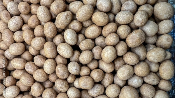 Fototapeta Peanuts in brown glaze are photographed close up.