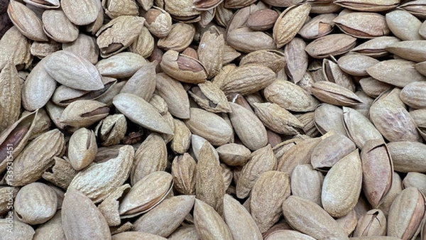 Fototapeta Slightly open almond shells lie scattered.