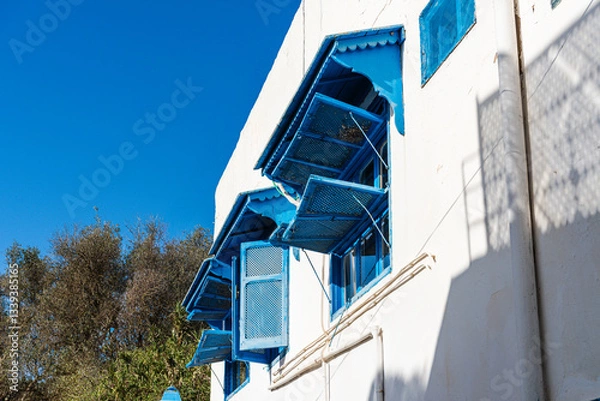 Fototapeta Blue wooden shutters open at a house in the UNESCO World Heritage site of Sidi Bou Said, Tunis, Tunisia