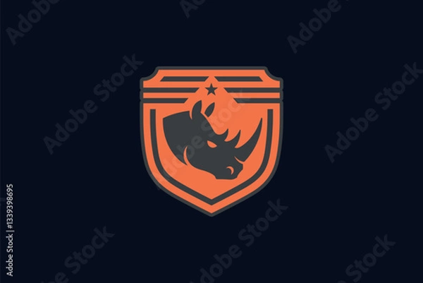 Fototapeta A shield-shaped emblem with a prominent rhino head in the center. The rhino is depicted in a stylized manner, with its horns and facial features clearly visible. Above the rhino, there's a small star.