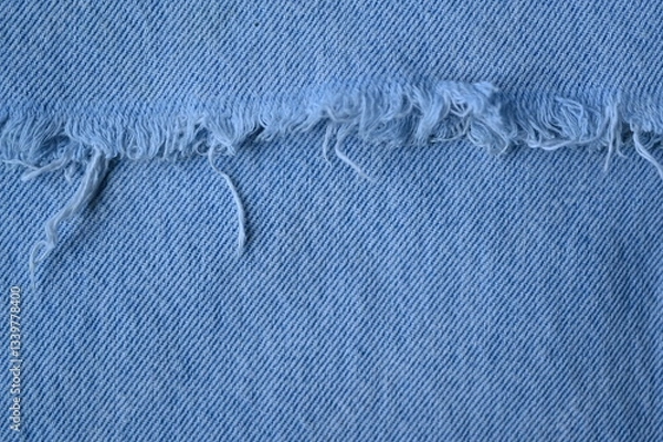 Fototapeta torn light grey denim surface, denim fringe , hole macro texture of blue denim, torn blue denim texture as background photo close up from above	
