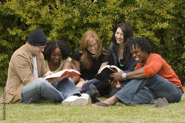 Obraz Zróżnicowana grupa ludzi czytających i studiujących.