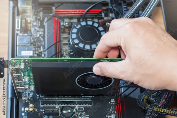 Obraz Installing a Graphics Card on the computer motherboard with hand