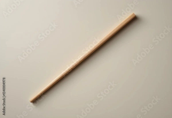 Fototapeta A single wooden chopstick rests diagonally on a smooth, neutral surface. Soft lighting highlights its texture and clean edges, creating a minimalist, balanced composition.