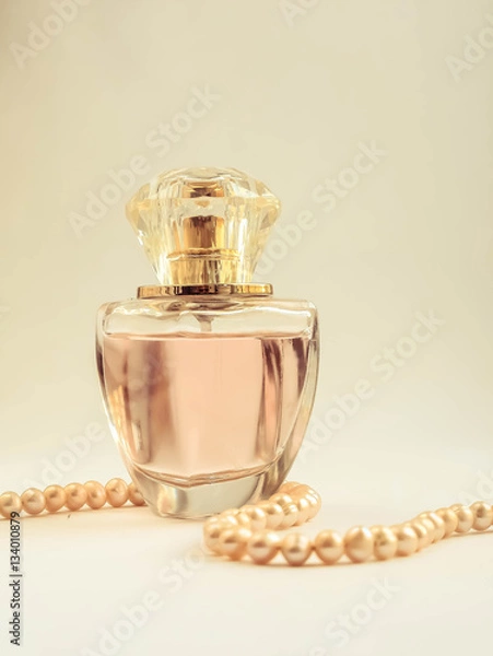 Obraz Женские духи в стеклянном флаконе. бусы из круглого жемчуга
