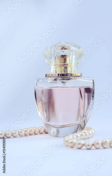 Obraz Красивый стеклянный флакон с женскими духами.  украшение из жемчуга серьги и кольцо.