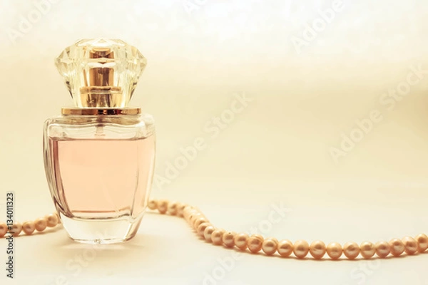 Obraz Женские духи в стеклянном флаконе. бусы из круглого жемчуга