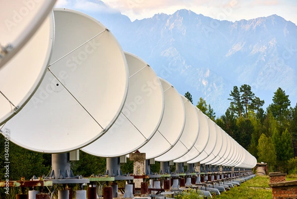 Fototapeta A row of radio telescope dishes against the background of mountains