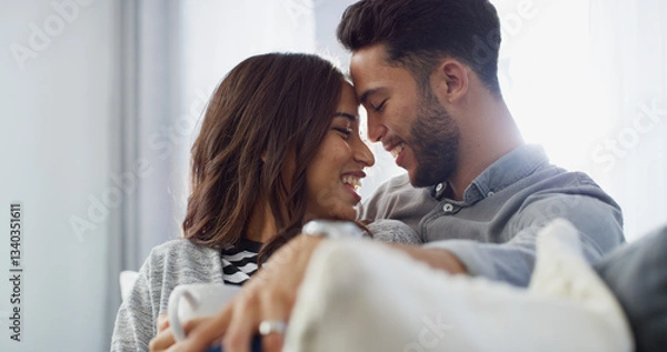 Fototapeta Comfortable, laughing and couple with coffee, home and love in living room with woman, hug and bonding. Happy, man and forehead touch with partner in lounge, tea and chilling in house or relationship