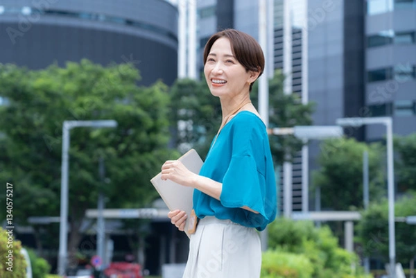 Fototapeta オフィス街で働くミドルのビジネスウーマン
