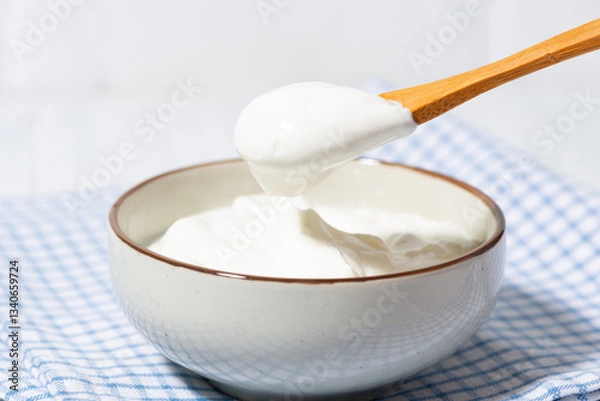 Obraz thick greek yogurt in a bowl and a spoon with yogurt