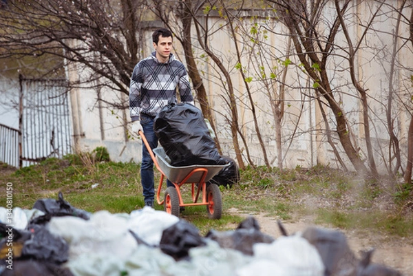 Obraz A volunteer collects trash left by tourists in nature