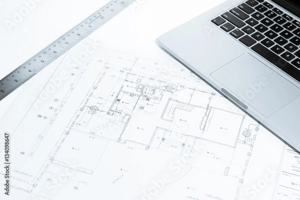 Obraz metal ruler and notebook over house construction blueprint with