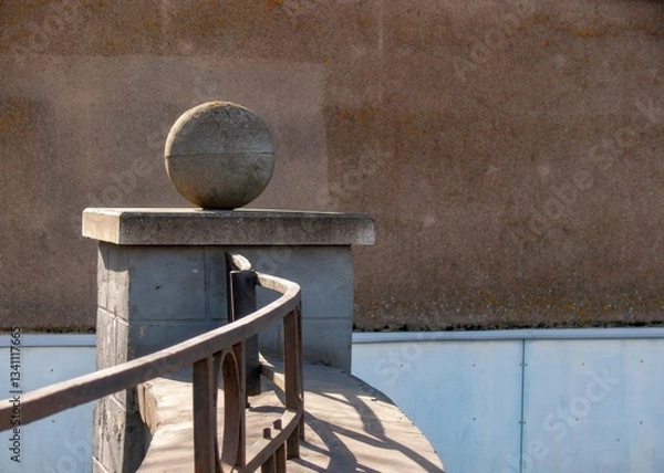 Fototapeta Stone sphere as a decorative element of fencing.