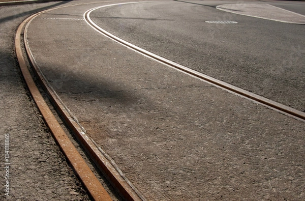Fototapeta Tram rails on a deserted asphalt road