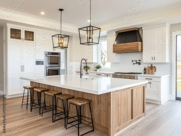 Fototapeta A kitchen with a large island and a wood counter top. There are four stools around the island