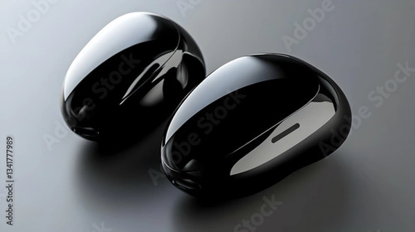 Fototapeta Two black, glossy, earbud cases or charging cases on a gray surface.

