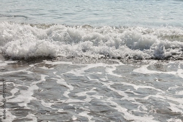 Fototapeta Ocean waves with white foamy water. Close-up of sea wave breaking. Water surface with waves and foam. Detail of ocean wave cresting. White water foam on sea surface