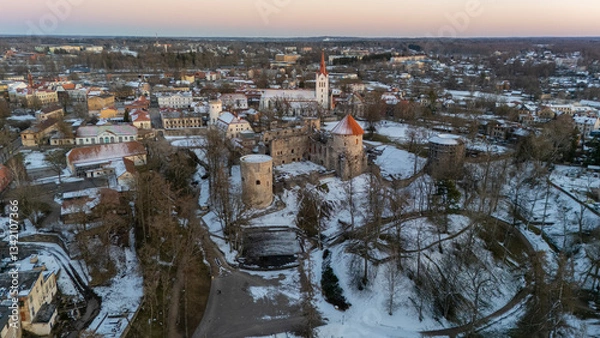 Fototapeta Cesis City, Latvia Aerial View With Medieval St. John’s Church and Ruins of the Beautiful Castle a Residence of the Livonian Order in the Middle Ages. Winter Evening Landscape at Sunset. City in snow