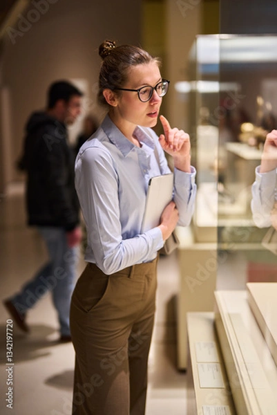Fototapeta visitor in historical museum looking at art object