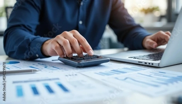 Fototapeta Close up businessman hand using calculator to budgeting and tax calculation monthly expenses. budget management and accounting on table. Business finance accounting banking concept.