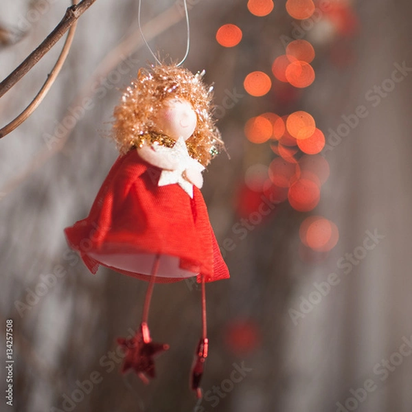 Obraz Red angel with star on a red garland background